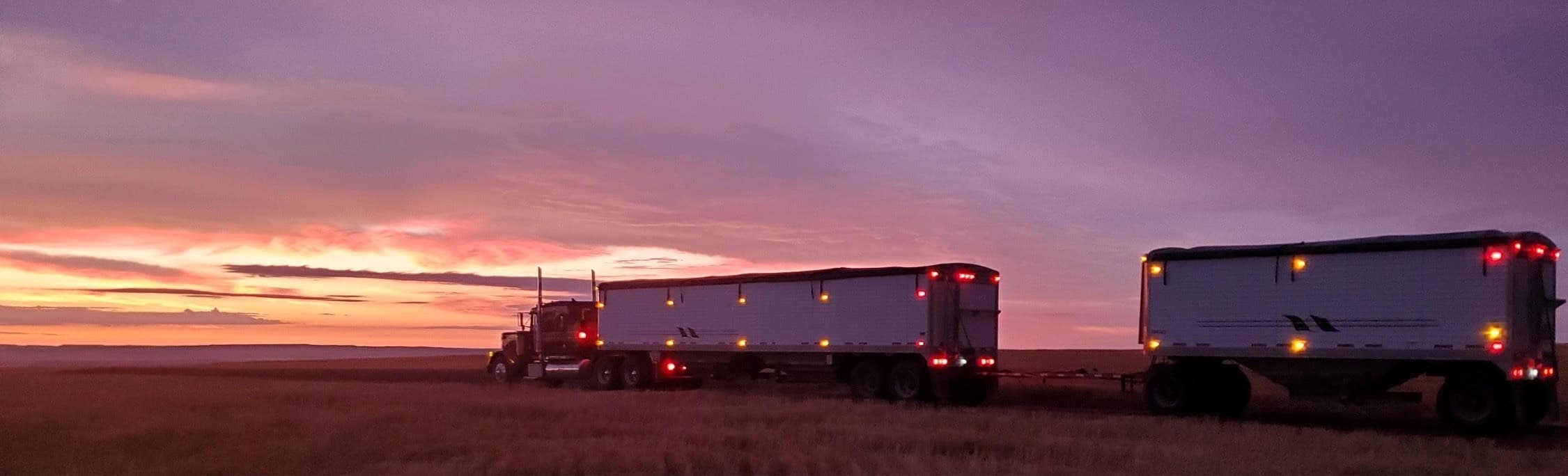 Twin bulk trailers at sunset